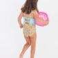 Child in colorful swimsuit holding inflatable donut
