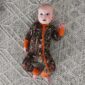 Baby in camouflage outfit on textured rug.