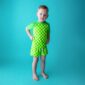 Child in green checkered outfit on teal background.