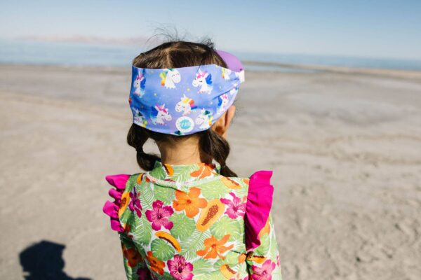 splash place swim goggles mask rainbow unicorn swim mask Child in colorful outfit on a beach