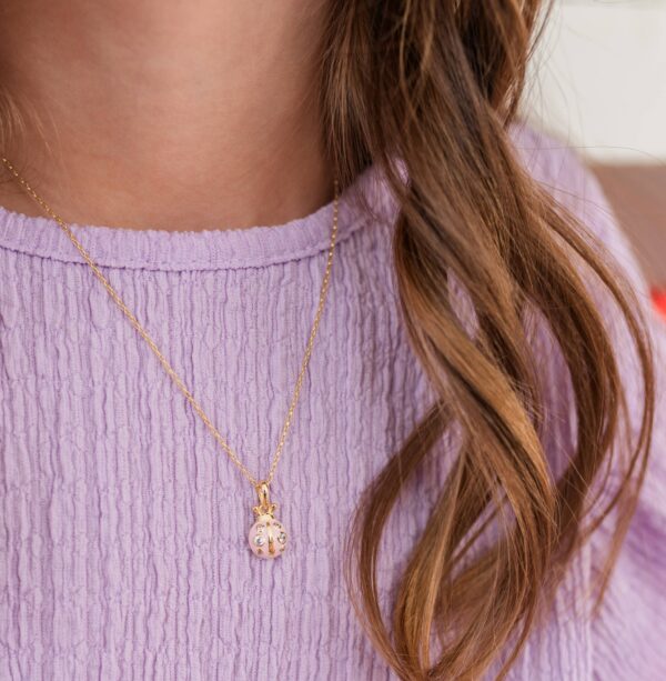 cherished moments 14k gold plated pink ladybug necklace for child, girls, kids Gold ladybug necklace on purple blouse.