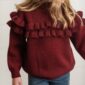 Child wearing red sweater with ruffles