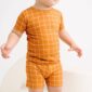 Toddler wearing orange grid-patterned outfit