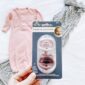 Pink baby gown and pacifier set on display.