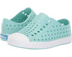 Turquoise perforated slip-on shoes with white soles.
