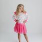 Girl in pink outfit striking a pose.