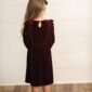 Child in red velvet dress facing away