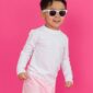 Child wearing sunglasses against pink background