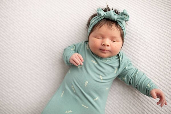 three little tots arrow print knotted newborn baby gown pajamas Sleeping baby in green outfit and headband.