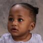 Baby with earrings looking upwards.